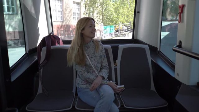 Young woman in automated remotely operated bus in Helsinki. Unmanned public transport on street.