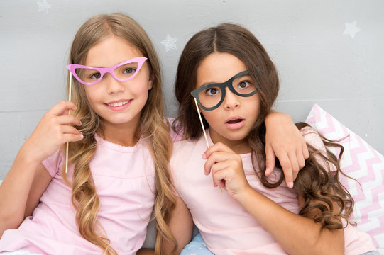 Something went wrong way. Children posing with confused face photo booth props. Pajamas party in bedroom. Friends cute and cheerful posing eyeglasses accessories. Girls having fun pajamas party
