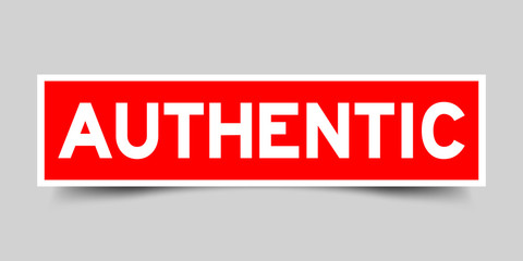 Red sticker with word authentic on gray background