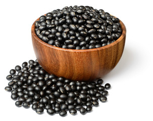 uncooked black bean in the wooen bowl, isolated on white