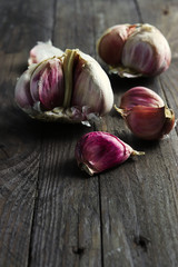 Garlic heads and cloves on dark wooden surface