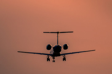 Airplane landing at sunset