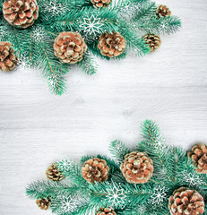 Obraz na płótnie Canvas Christmas and New Year's composition. The pine cones, spruce branches on a wooden white background, top view