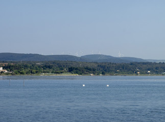 Obraz premium Le Massif de la Gardiole avec ses éoliennes dominant l'Etang de Thau vus de Balaruc-les-bains