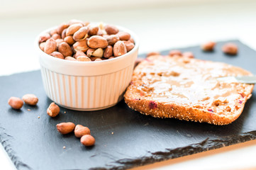 Peanut butter sandwich on chalk board and raw peanuts