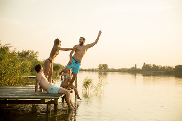 Group of young people having fun on pier at the lake