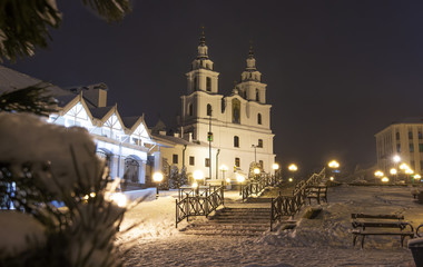 Fototapeta na wymiar Winter Minsk at night. Christmas in Minsk, Belarus. Cityscape of Belarus capital. Famous church orthodox tower in center of city. Xmas background. New Year time in December at Minsk.