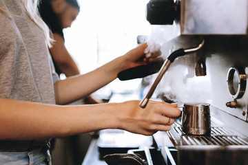 A modern expensive coffee machine is shown in work in  modern cozy coffee shop.