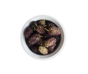 Mulberries in a wooden bowl with copy space for text. Ripe and tasty mulberry isolated on white background. Top view.