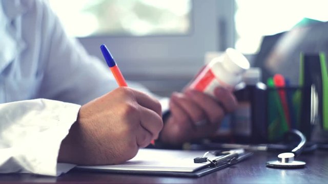 Doctor man hands writing rx prescription