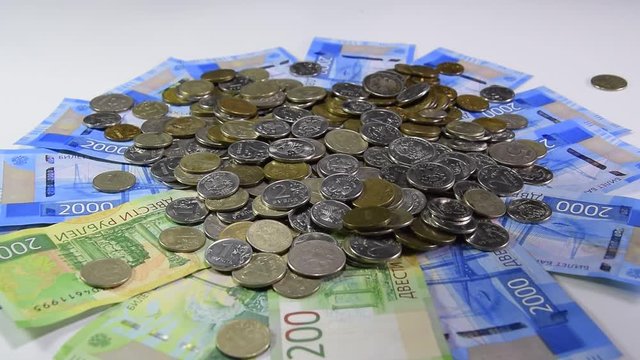 A pile of coins and kopecks rubles on paper denominations of 200 and 2000 denominations. Throwing coins into a common heap. Russian rubles.