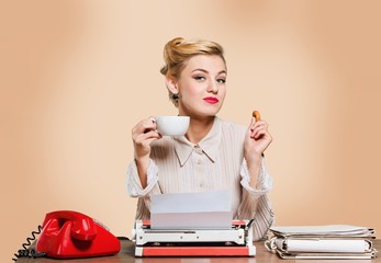 Fototapeta premium Attractive young woman working on vintage typewriter