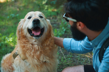 Handsome young man with golden retriver outdoors