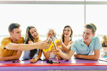 A company of good-looking friends laughing, drinking yellow cock