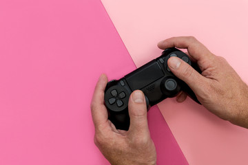 Man playing video game with controller bright pink background