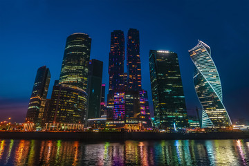 Obraz na płótnie Canvas Panorama of Moscow City - new modern International business center with futuristic architecture skyscrapers buildings reflected in Moscow river at night