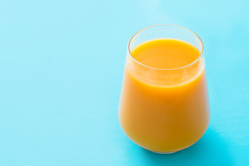 Mango Lassi dessert. Traditional Indian drink on blue background. Copyspace