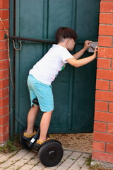 The brunette boy on the gyroscope left to open the door. - Who's come? Life in the village in the summer. Holiday.