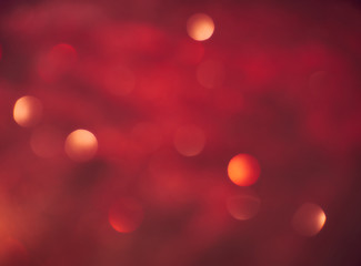 New Year Christmas Blurred background. Abstract defocused gold, white, red and yellow glitters texture on black background. Shining glowing snow effects