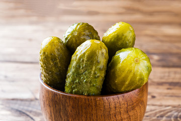 Pickled cucumbers in a wooden bowl dark rustic background