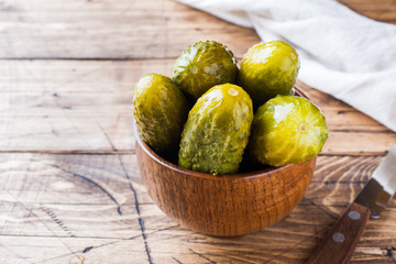 Pickled cucumbers in a wooden bowl dark rustic background