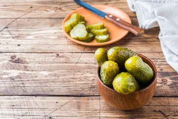 Pickled cucumbers in a wooden bowl dark rustic background