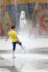 A kid is playing near the fountain