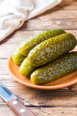 Pickled cucumbers in a wooden bowl dark rustic background