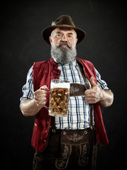 Germany, Bavaria, Upper Bavaria. The smiling man with beer dressed in in traditional Austrian or...