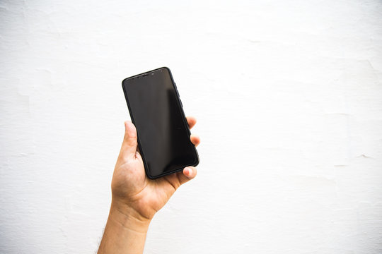a hand rising a mobile phone against white background - Powered by Adobe