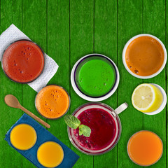 Set of different vegetable juices and fruit drinks, mint leaf and lemon on rustic green wooden table.  Concept of healthy eating and drinks. Top view. Copy space.