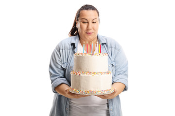 Overweight woman blowing candles on a birthday cake