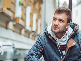 Portrait of young man in the street listening music