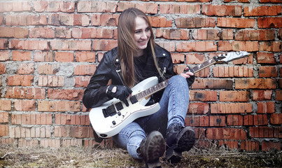 Beautiful young girl rocker with electric guitar. A rock musicia