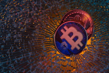 Bitcoin crypto currency bear market or depression concept, metal clamp squeezing  Bitcoin physical coin , crisis on cryptocurrency investment trading metaphor.On broken glass background