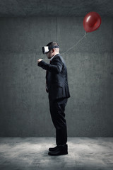Businessman mit VR Brille und Luftballon in der Hand