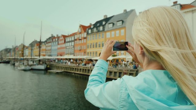 The tourist photographs the famous houses on the Nyhavn canal. Tourism in Denmark concept