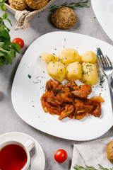Fresh beef goulash served with boiled potatoes on white plate