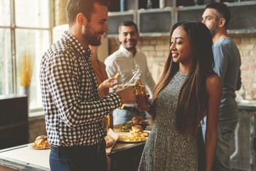 Party with best friends. Group of cheerful young people enjoying home party with snacks and drinks while communicating on the kitchen.
