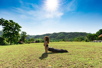 Beautiful Attractive Asian woman sitting practice Cobra Pose with yoga meditation relax and refresh health on green grass feeling happiness and comfortable in garden,Yoga Healthy Concept