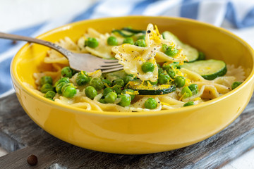 Farfalle pasta with zucchini and green peas.