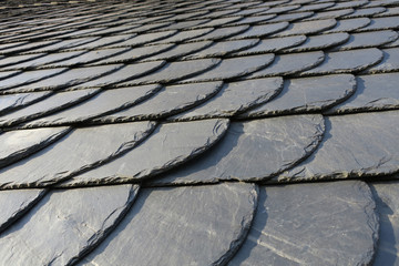 roofing: pattern of gray slate on an antique roof lightend by the sun