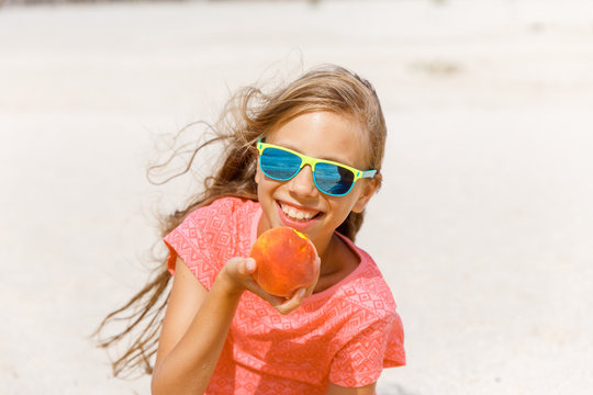 Girl In Glasses On The Beach Eating A Peach