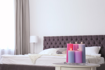 Fototapeta na wymiar Burning candles on table in light bedroom