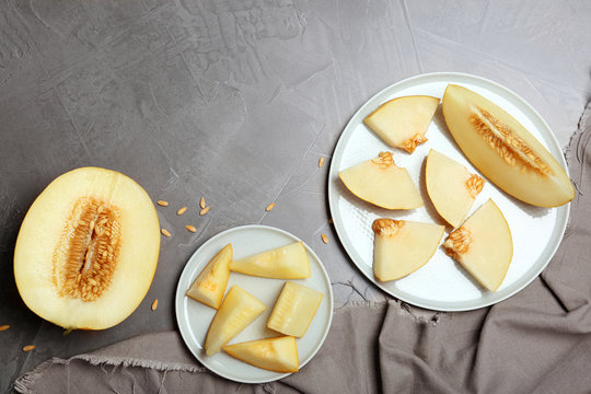 Flat lay composition with delicious cut melon on table. Space for text