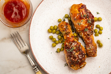 Baked chicken legs with peas, beans and fresh herbs. Chicken drumsticks with tasty sause and greens.