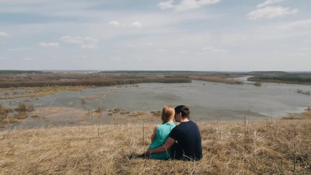 Trandy couple sits by the river. Holidays, vacation, love