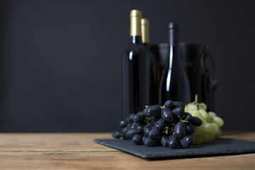 Wine Bottle with grapes in a black background