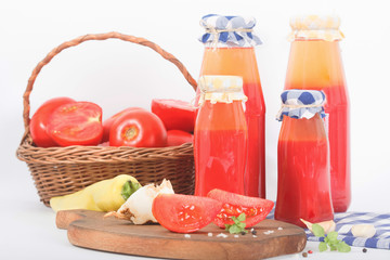 Tomato paste, puree in bottles ready for winter time and fresh tomatos on white background