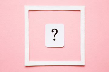Card of question mark in white frame on pastel pink background. Soft light color. Women issues....